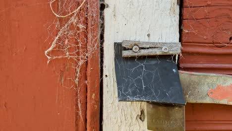 4K-60FPS-Zooming-in-View-of-a-Spider-Web-on-a-Padlock-and-an-Old-Door-on-Shed---Dolly-Shot