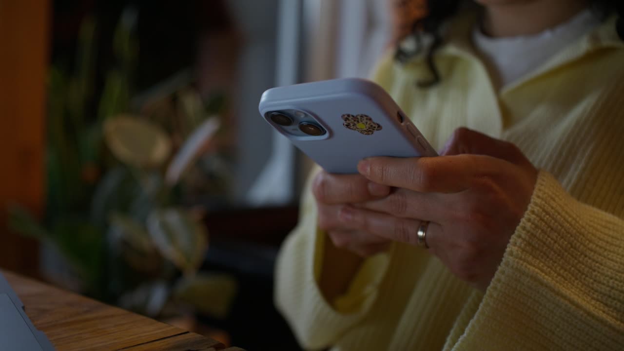 Donna che usa uno smartphone in un bar