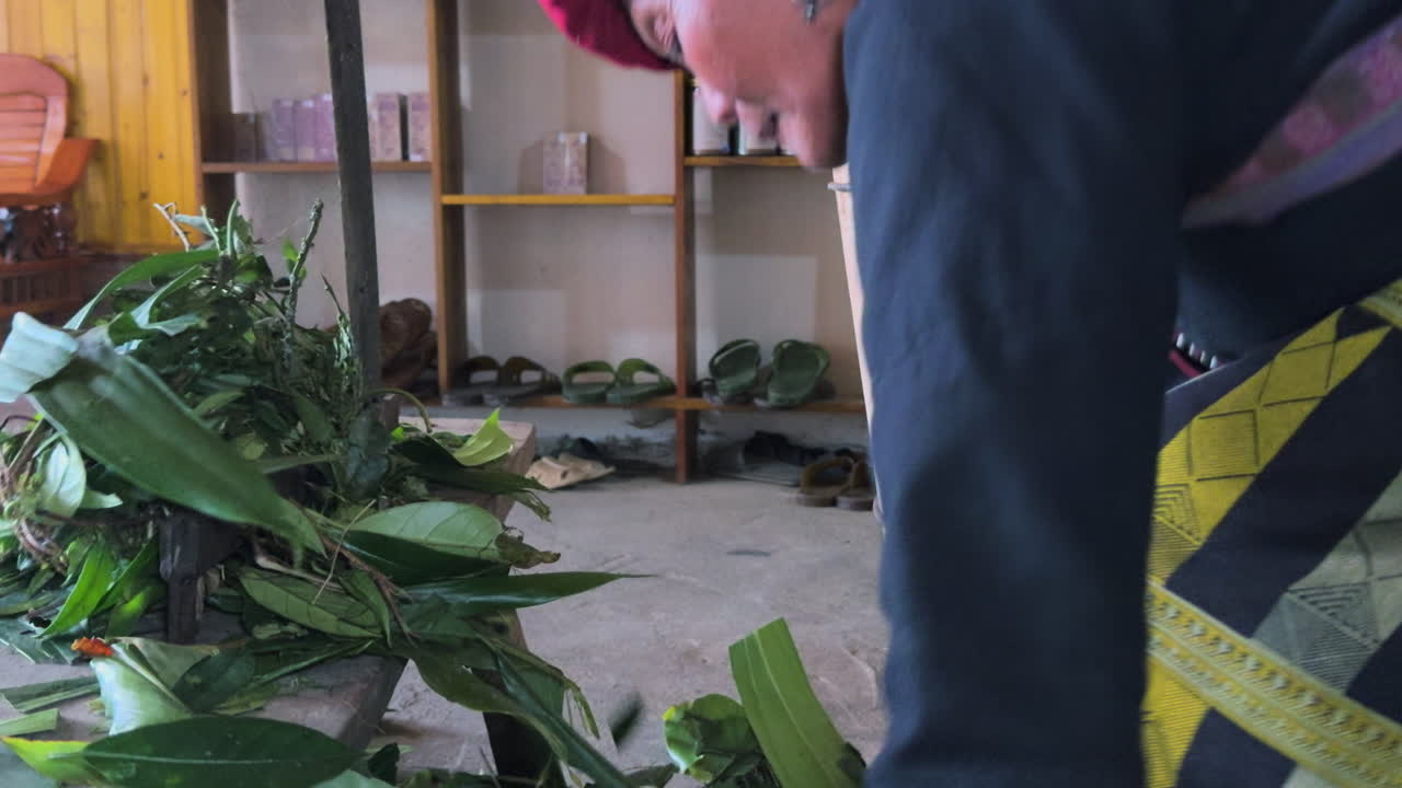 Close-up of traditional hands cutting fresh medicinal plants with a blade in Tả Phìn, Sa Pa.