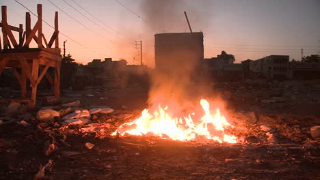 an open fire burns on the streets of haiti following an earthquake