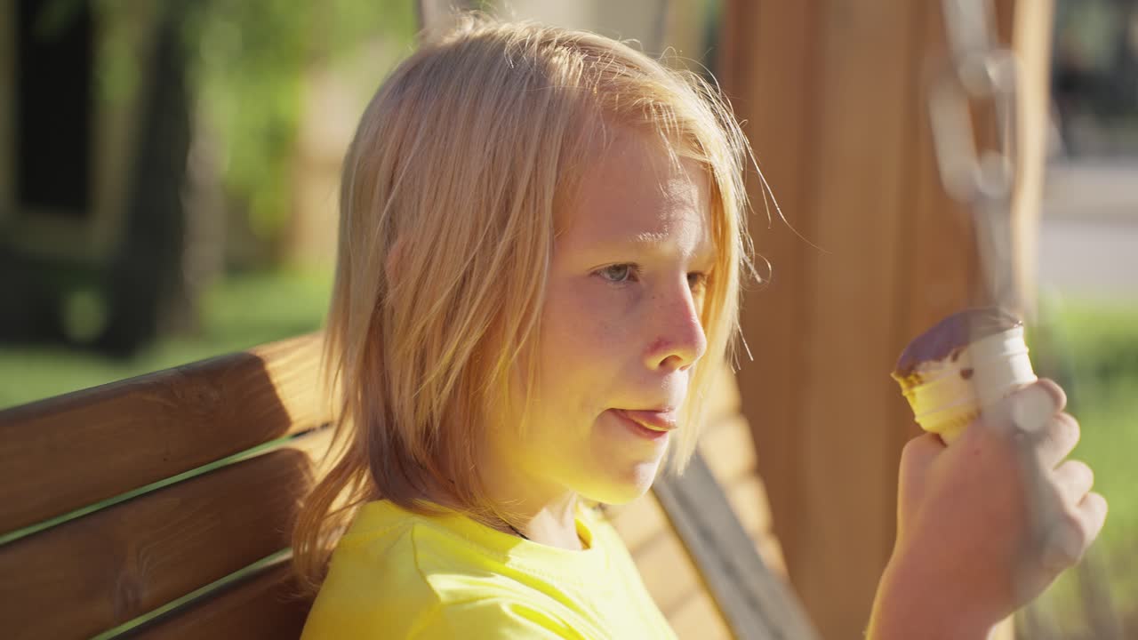 Boy eating ice cream on a swing
