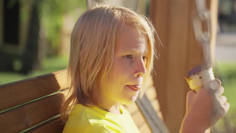 boy eating ice cream on a swing