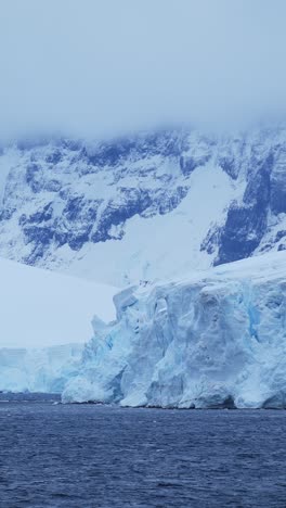 Antarktischer-Gletscher,-Nahaufnahme-Des-Meeres-An-Der-Küste-Mit-Bergen,-Wunderschöne-Dramatische-Landschaft-Der-Antarktischen-Halbinsel-Mit-Schnee-Und-Eis,-Vertikales-Video-Für-Soziale-Medien,-Instagram-Reels-Und-Tiktok