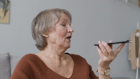 Senior-Woman-Making-Hands-Free-Phone-Call-At-Home