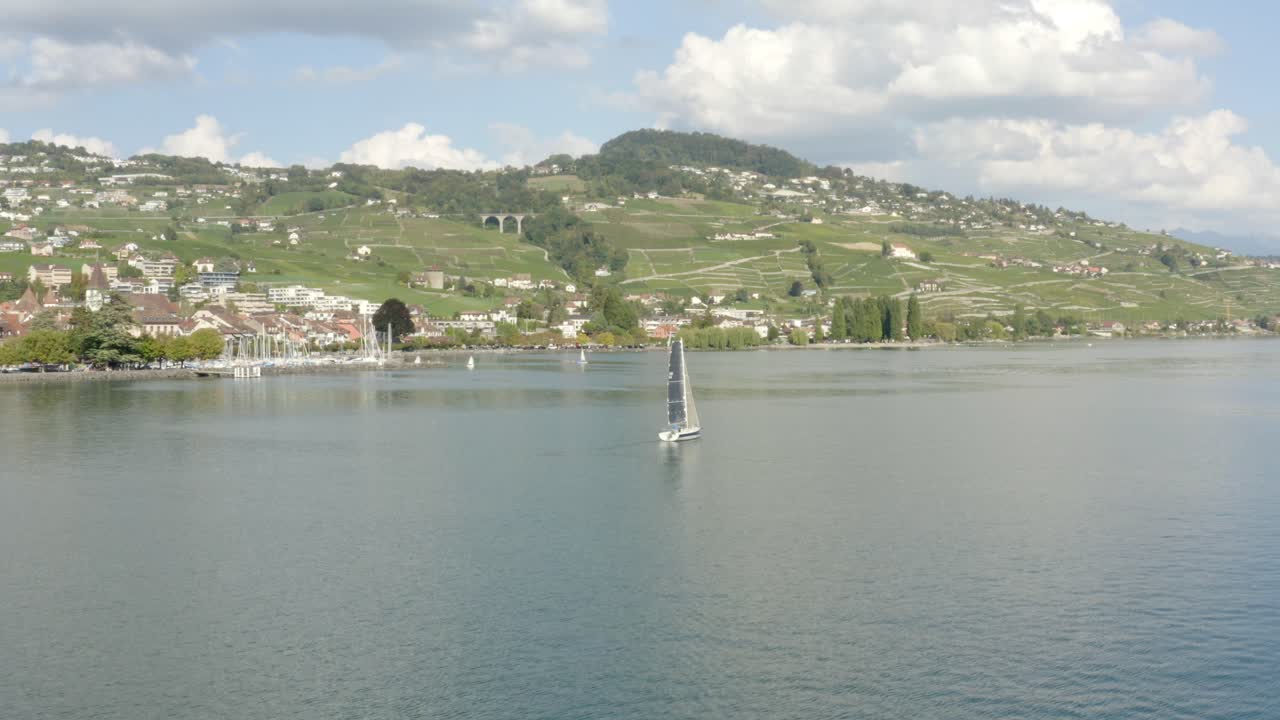 In volo accanto a una barca a vela, poi sorvolando la città medievale di Lutry e il suo porto, Lavaux - Svizzera