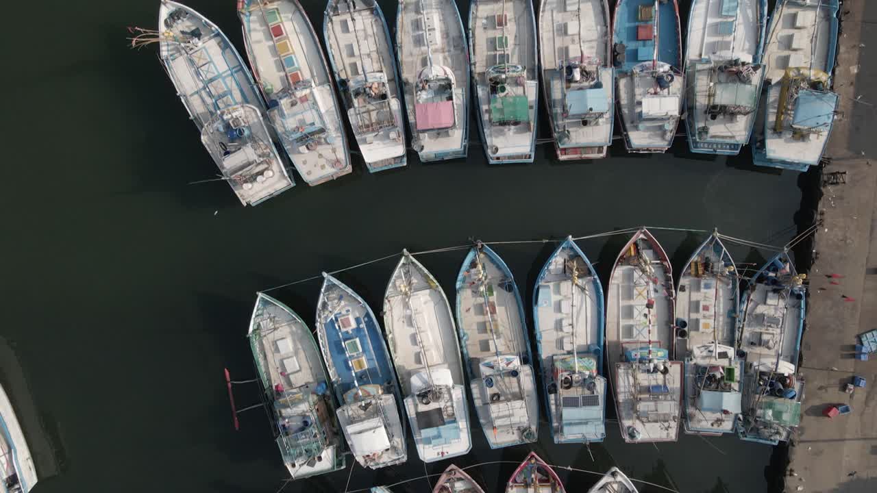 el sobrevuelo mira directamente hacia abajo en el patrón de barco de pesca en la marina apretada