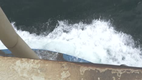 Front-Of-Industrial-Ferry-Boat-With-White-Water-Splashing-Over-Bow-And-Rope-In-Foreground,-Tasmania,-Australia