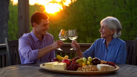 couple toasting with wine and enjoying a cheese platter at sunset