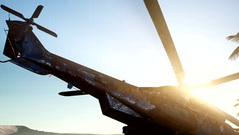 old rusted military helicopter in the desert at sunset