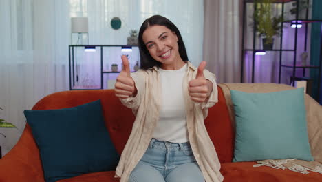 Happy-young-woman-looking-approvingly-at-camera-showing-thumbs-up,-like-positive-sign,-good-news