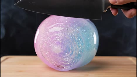 cutting a colorful glitter gelatin sphere with a knife