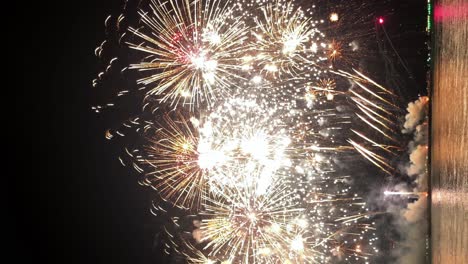 tomada vertical de una exhibición de fuegos artificiales en una celebración de un festival internacional en uno de los destinos turísticos del sudeste asiático