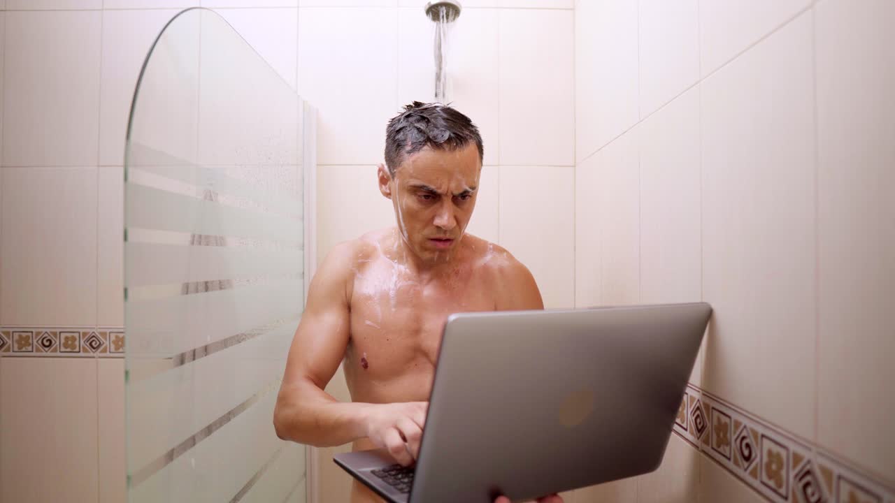 Man working on laptop and phone in shower