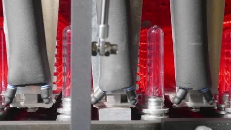 a closeup shot of how plastic pet preforms are being put into a heating machine