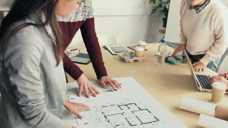 Woman-architect-showing-plans-to-hipster-startup-business-team