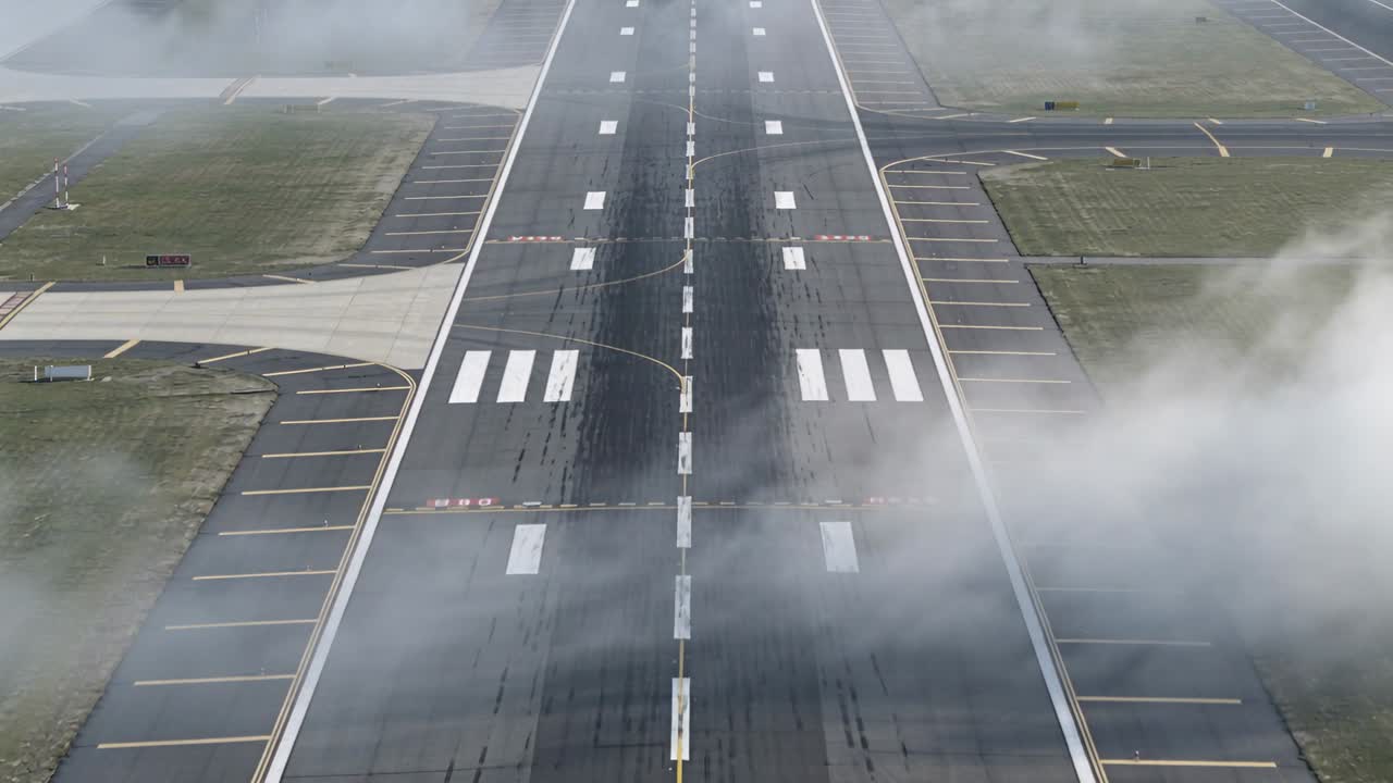 Bassa nebbia che si sposta sulla linea centrale della pista e oscura la segnaletica nell'aerodromo, poi rivelando il numero 25.