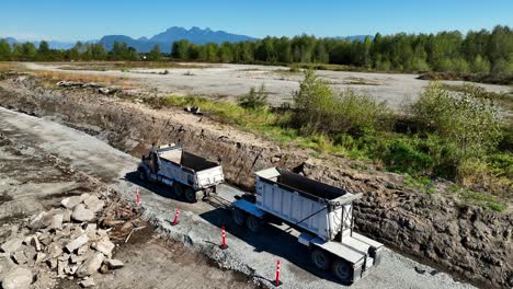 dump truck towing dump trailer to the construction site