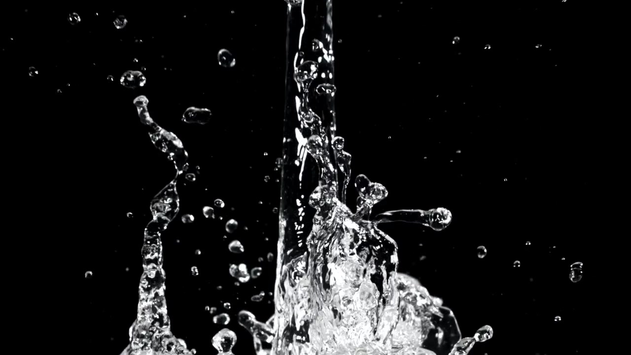 Dynamisk vandsprøjt og dråber i slowmotion på sort baggrund
