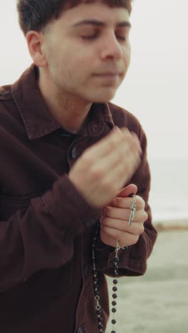 Man Crying While Praying On The Shore During Winter