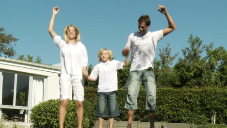 parents and child jumping on a trampoline