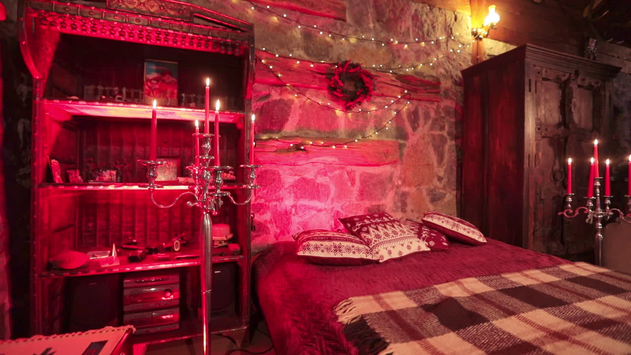 Old-fashioned countryside bedroom in the private manor. Wooden carved furniture, candles and decoration lights in the room for two.
