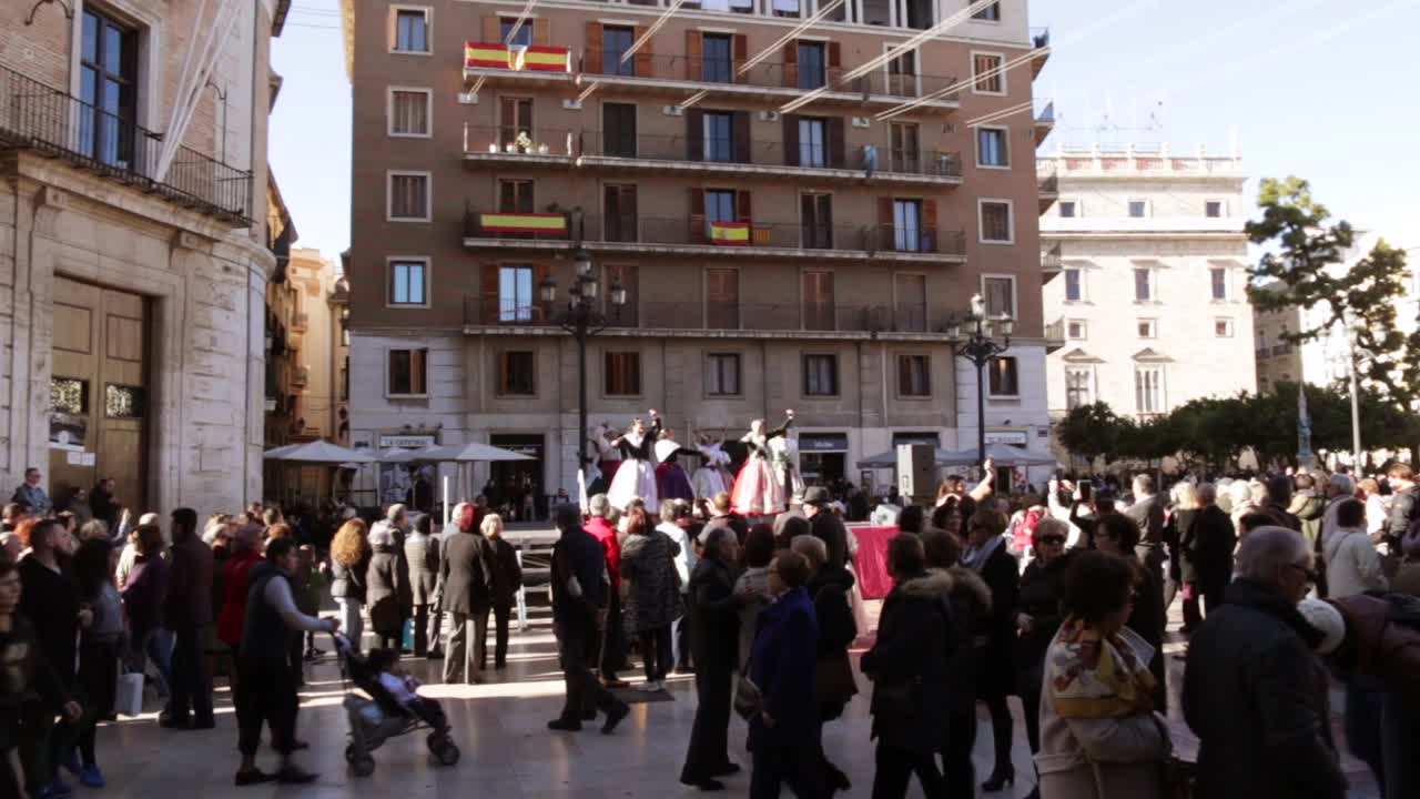 Spanish women dancing in spain at a festival in valencia in open square city center with warm weather and sunny skies shot with a wide angle
