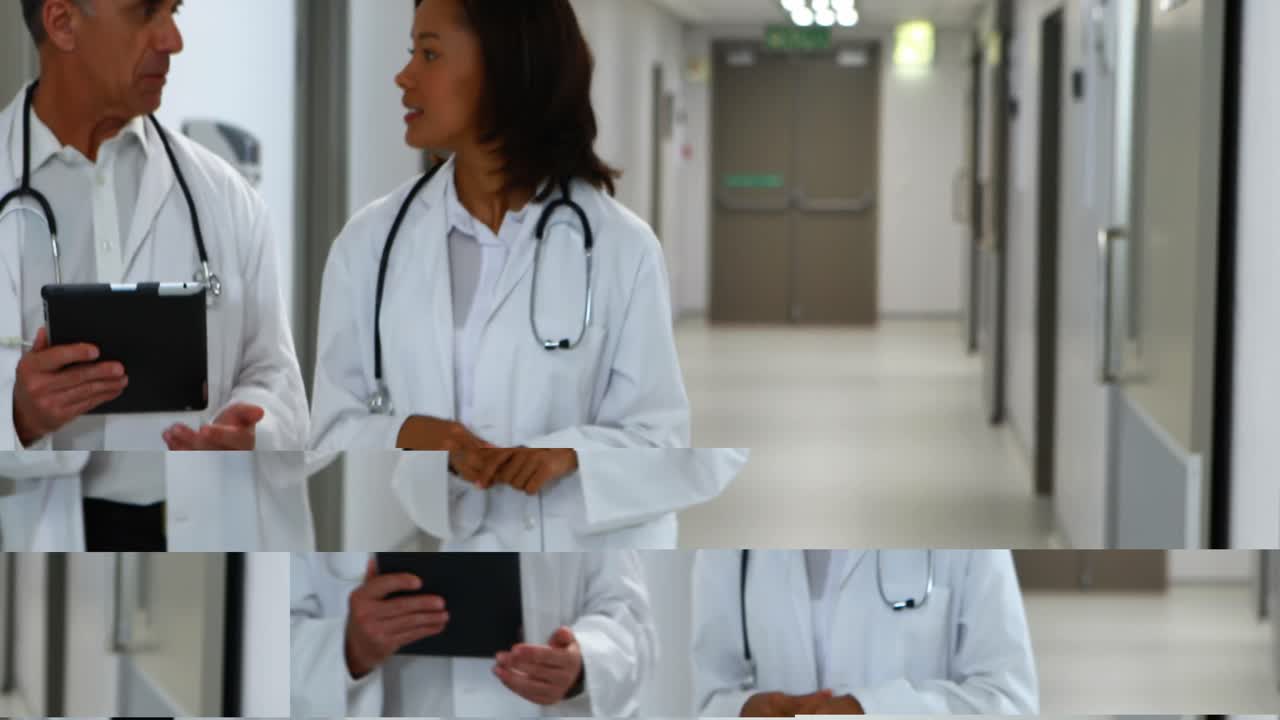 Doctors discussing over digital tablet while walking in corridor