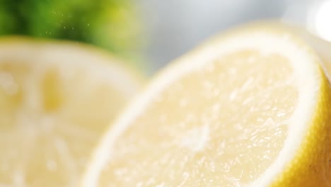 limón fresco en rodajas con partículas diminutas que caen en cámara lenta, tiro de muñeca, enfoque selectivo