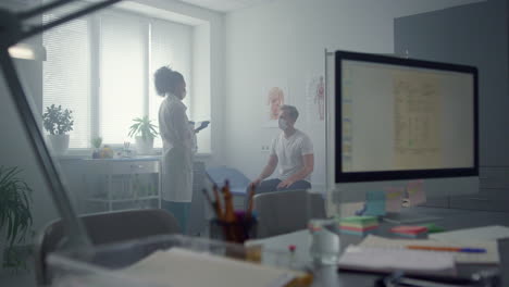 woman physician using tablet computer consulting patient in hospital office.