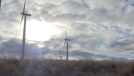 wind turbines driving by with clouds