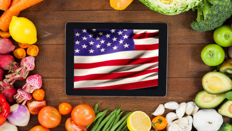 animation of fresh fruit and vegetables and flag of united states of america on tablet