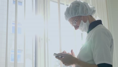 doctor using smartphone near window