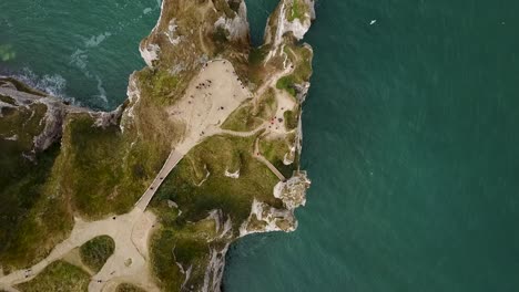 flying above the pathways that lead to the rocky arch of etretat on the coastline of france