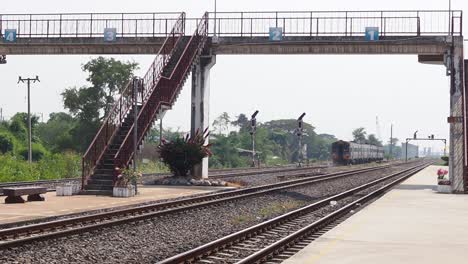 un tren se mueve a través de las vías en una estación de tren.