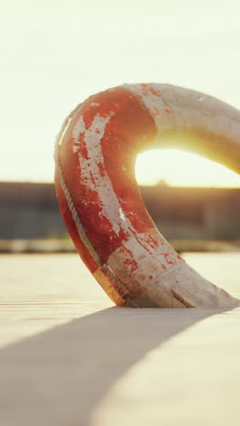 red and white life preserver on a sandy beach at sunset