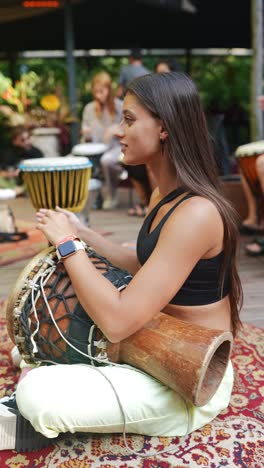 woman playing djembe drum at outdoor music event