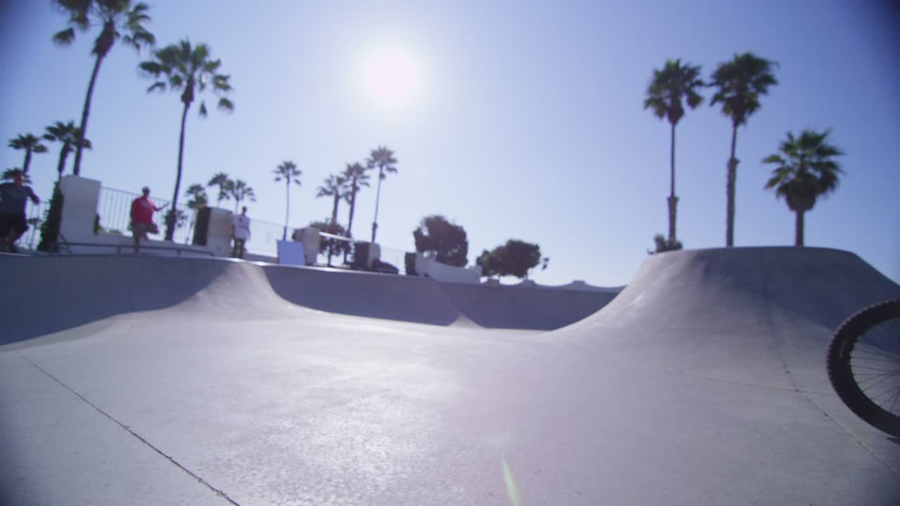 카메라는 bmx 자전거 라이더가 점프하고 스케이트파크 1의 벽을 타는 것을 따라갑니다.