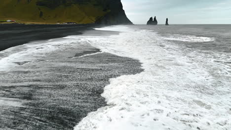 stormy weather at the coastline. strong white foamy waves roll on the black beach. shoreline of iceland.