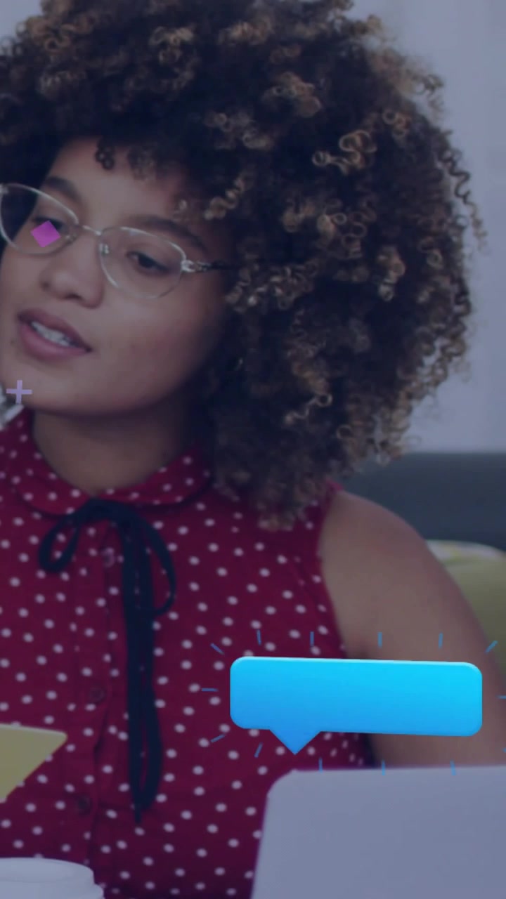 Video verticale: Donna in abito a pois rossi che si gira verso gli avvisi che compaiono sul divano per guardare il portatile, con spazio per il testo