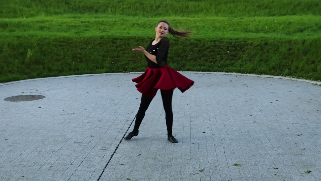 Stunning female dancer practices outside in the park