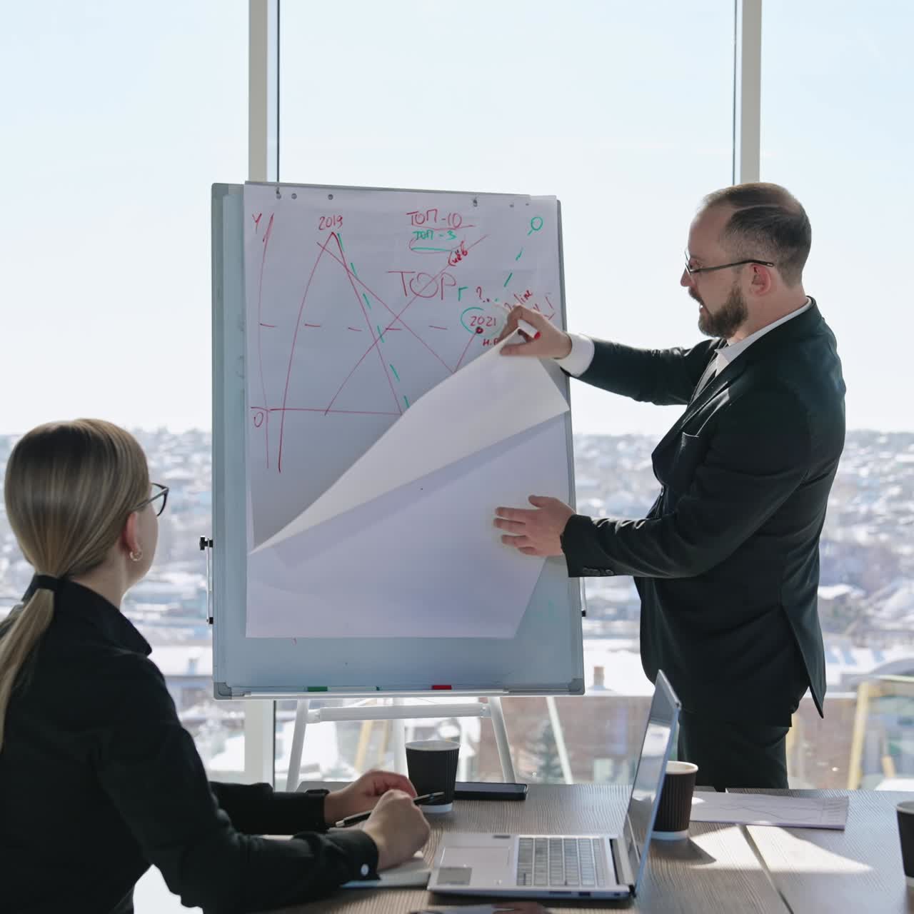 Professional team having a meeting. Businessman showing graphics and starting new paper. Friendly environment in the office