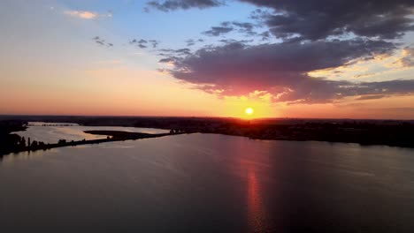 deep golden amber sunrise reflects off a shimmering moses lake, washington, aerial