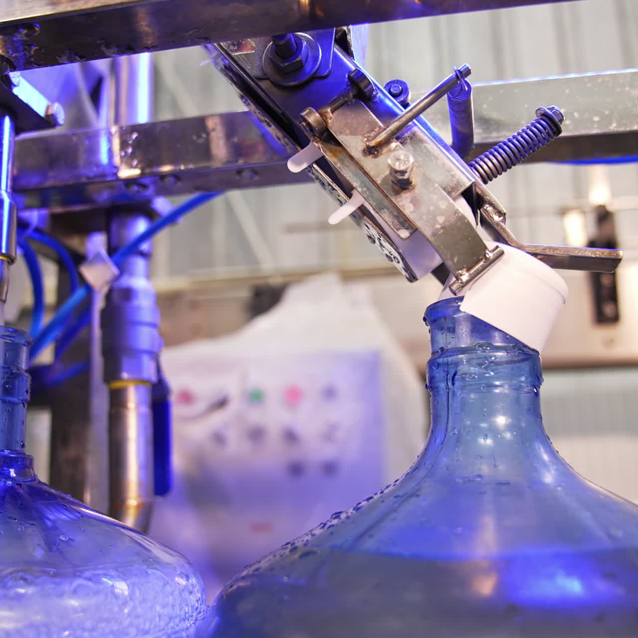 Automated line for water production. Big bottles are filled with clean water at the food factory. Close up
