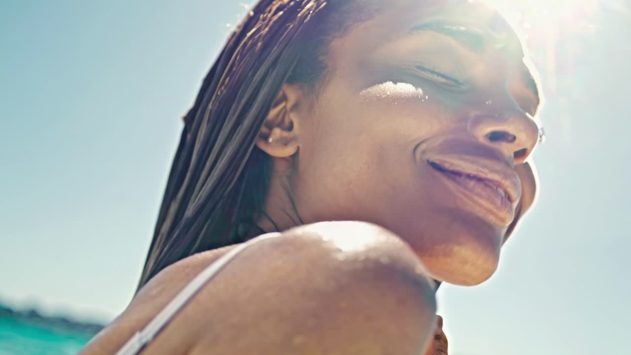 Vídeo em close-up de uma pessoa sorrindo sob a luz do sol, capturado de um ângulo baixo
