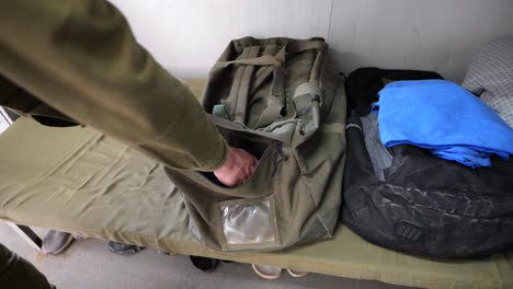 Soldier-storing-practice-grenade-in-duffle-bag,-close-up