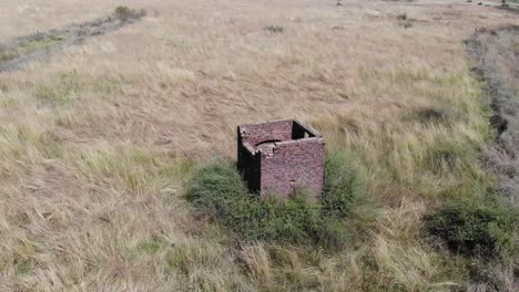 Luftdrohnenaufnahme-Eines-Verlassenen-Wachhauses-Auf-Einem-Feld