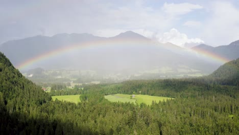 Aerial-View-of-Colorful-Rainbow-Above-Beautiful-Landscape-and-Mountain