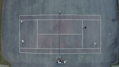 4k top view drone shot of people playing tennis on a tennis court outdoors