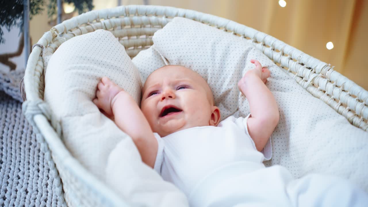 Neonato turbato che piange in una culla bianca