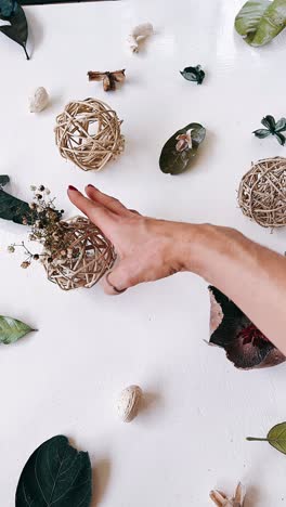 hand reaching for dried flowers arrangement